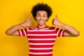 Photo of young funny dude guy raise double thumbs up approving wear striped shirt isolated yellow color background Royalty Free Stock Photo