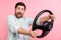 Photo of young funny young man drive steering wheel crazy speed wear shirt unexpected fast his new car isolated on pink