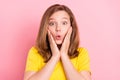 Photo of young girl amazed shock surprised fake novelty news hand touch cheeks isolated over pink color background