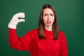 Photo of young girl annoyed mocking show hand blah blah chatting wear gloves isolated over green color background