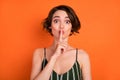 Photo of young girl finger cover lips shh keep secret confidential private isolated over orange color background Royalty Free Stock Photo
