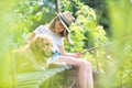 Young girl fishing while sitting with dog on pier Royalty Free Stock Photo