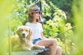 Young girl fishing while sitting with dog on pier Royalty Free Stock Photo