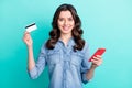 Photo of young girl happy positive smile hold bank card shopping onling smartphone isolated over teal color background