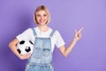 Photo of young girl happy positive smile hold soccer ball point finger empty space ad advise select isolated over violet Royalty Free Stock Photo