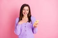 Photo of young girl happy positive smile look cellphone hand on chest thankful pleased isolated over pink color