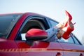 Photo of young girl`s legs in red shoes sticking out of red car window Royalty Free Stock Photo