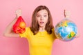 Photo of young girl shocked hold hands apple globe plastic bag ecology problem isolated over pink color background