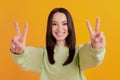 Photo of young girl show fingers victory v-sybmol hello greetings isolated over yellow color background