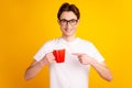 Photo of young guy indicate finger mug advertise choice promo espresso isolated over yellow color background Royalty Free Stock Photo