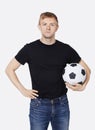 Portrait of a young handsome man in casual wear holding soccer ball over white background Royalty Free Stock Photo