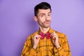 Photo of young handsome man elegant confident fix correct bowtie prepare date isolated over violet color background Royalty Free Stock Photo