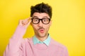 Photo of young handsome serious shocked amazed surprised man in funky glasses isolated on yellow color background