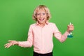 Photo of young happy cheerful positive amazed boy hold hand chemical glass isolated on green color background
