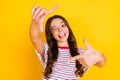 Photo of young happy cheerful smiling funky funny girl taking picture showing tongue on yellow color background