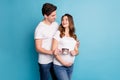 Photo of young happy excited positive smiling family hold ultrasound picture of baby isolated on blue color background