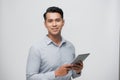 Photo of young happy man standing over white background using tablet computer