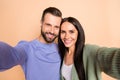 Photo of young happy positive smiling cheerful couple wife and husband taking selfie isolated on beige color background Royalty Free Stock Photo