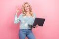 Photo of young lady curly hair wear cardigan daisy flower print show okey sign hold laptop new software isolated on pink Royalty Free Stock Photo