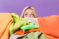Photo of young lady hide face behind big pile stack clothes look up empty space isolated on violet color background