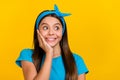 Photo of young lovely excited girl curious look empty space think isolated over yellow color background