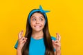 Photo of young lovely girl curious look empty space wish luck pleading isolated over yellow color background