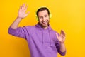 Photo of young man happy positive smile have fun dance party listen music earphones isolated over yellow color Royalty Free Stock Photo