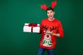 Photo of young man happy positive smile hold present box party winter holiday christmas isolated over green color Royalty Free Stock Photo
