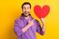 Photo of young man happy positive smile point finger heart ad advice choice isolated over yellow color background Royalty Free Stock Photo