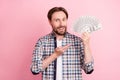 Photo of young man happy positive smile show hand money cash dollars rich isolated over pink color background Royalty Free Stock Photo