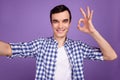 Photo of young man make selfie show fingers okay symbol good perfect isolated over violet color background