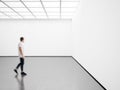 Photo of young man in modern gallery looking at the empty canvas. Blank mockup, motion blur Royalty Free Stock Photo