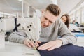 photo of a young man and other seamstresses sewing with sewing machine in a factory