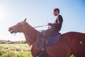 Young man riding a horse in the field Royalty Free Stock Photo