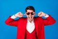 Photo of young man unhappy angry mad cover fingers ears loud noise mad isolated over blue color background Royalty Free Stock Photo