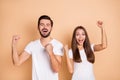 Photo of young married couple happy positive smile rejoice win victory success goal fists hands isolated over beige