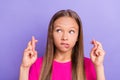 Photo of young minded curious small girl look empty space crossed fingers isolated on purple color background