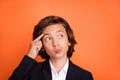 Photo of young minded thoughtful small boy hold finger temple look empty space on orange color background