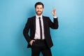 Photo of young model businessman handsome showing okey sign good job nice feedback office services isolated on blue Royalty Free Stock Photo