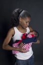 young African amrican young mother lovingly holding her newborn baby in her lap Royalty Free Stock Photo