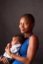 Photo of a young mother lovingly holding her newbornbaby in her lap and looking at her baby with love Royalty Free Stock Photo