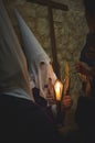 Young Nazareno with Cone-shaped Capirote and Candle in Holy Week Procession