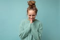 Photo of young positive beautiful blonde woman with sincere emotions wearing casual blue pullover isolated over blue Royalty Free Stock Photo