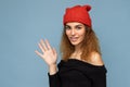 Photo of young positive cute nice brunette woman curly with sincere emotions wearing stylish black crop top and red hat Royalty Free Stock Photo