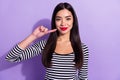 Photo of young positive good mood pretty asian woman recommend red lipstick advertise isolated on violet color