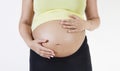 Midsection of young pregnant woman with hands on stomach against white background Royalty Free Stock Photo