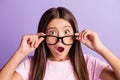 Photo of young preteen girl amazed shocked surprised fake novelty news hands touch glasses isolated over violet color