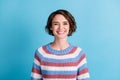 Photo of young pretty cheerful girl funny look face wear colorful striped pullover isolated blue color background