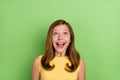 Photo of young pretty girl excited look empty space unexpected reaction  over green color background Royalty Free Stock Photo