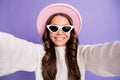 Photo of young pretty girl happy positive smile make take selfie travel trip wear sunglass isolated over purple color Royalty Free Stock Photo